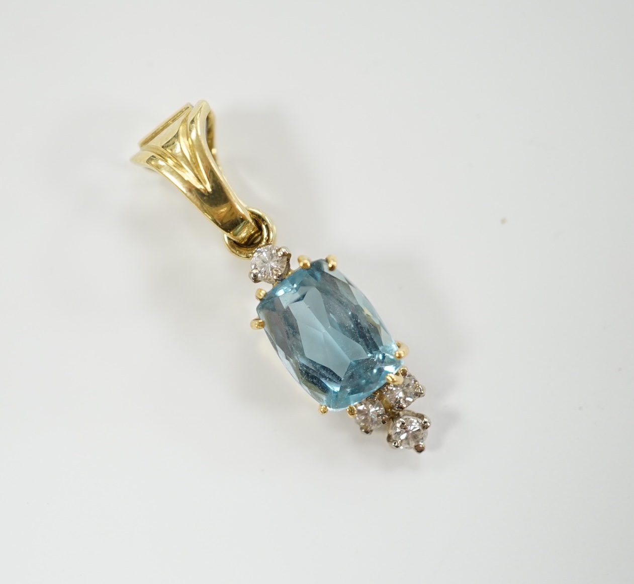 A yellow metal, single stone blue topaz and four stone diamond set pendant, overall 28mm, gross weight 2.6 grams.